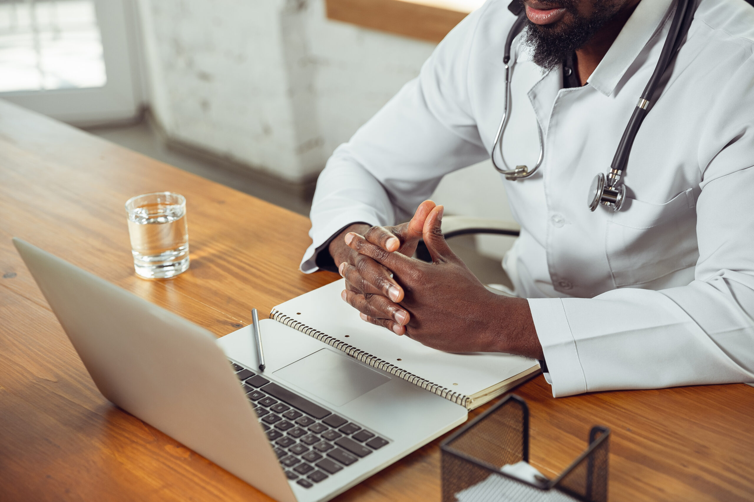 African-american doctor consulting for patient, working in cabinet, close up